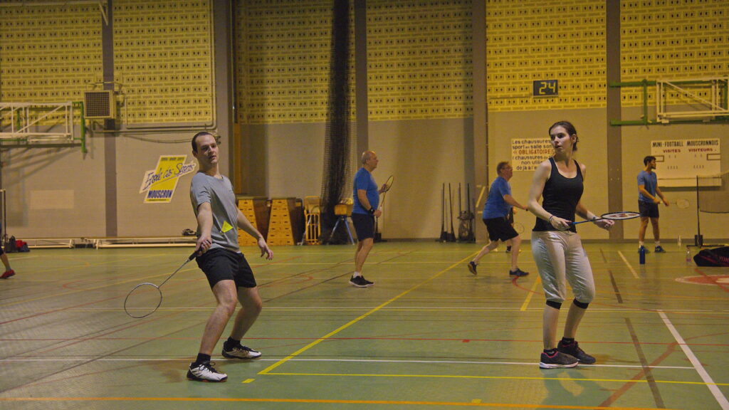 Deux joueurs lors d'un match au Badminton Club de Dottignies, l'un frappe le volant